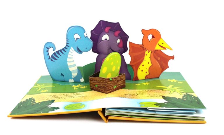 Pop-up-Buch mit drei bunten Dinosauriern auf einer Wiese.